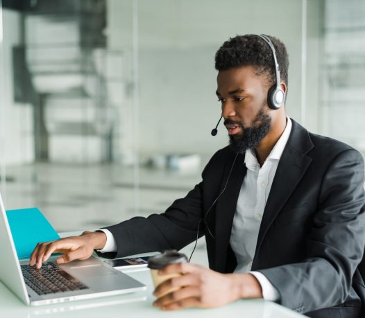 african-american-man-customer-support-operator-with-hands-free-headset-working-office-min